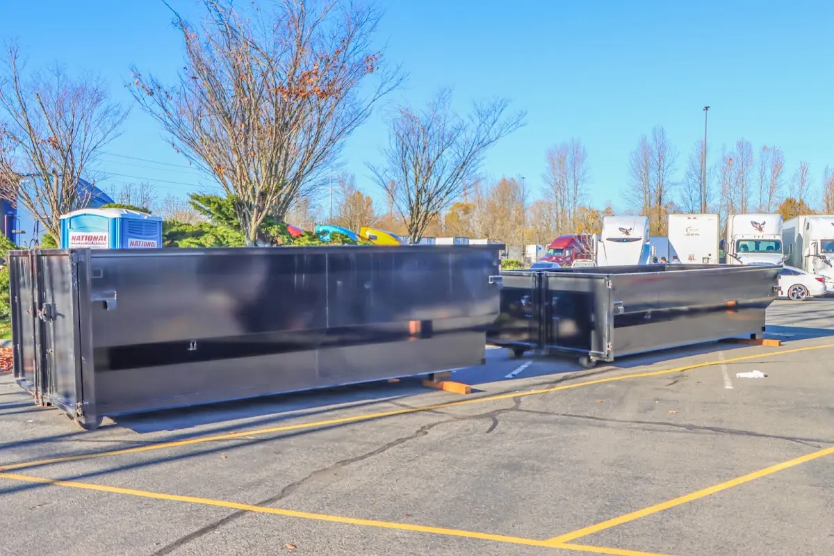 Professional dumpster rental service with roll-off container on residential driveway in Tuscaloosa